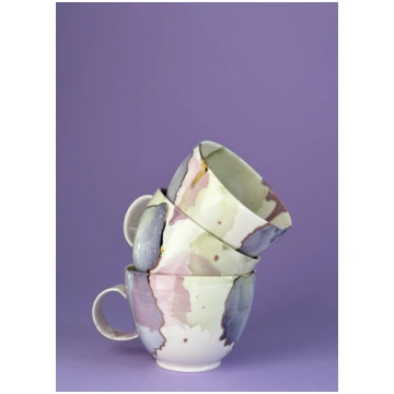 Zemā porcelāna krūze violetos un zaļos toņos